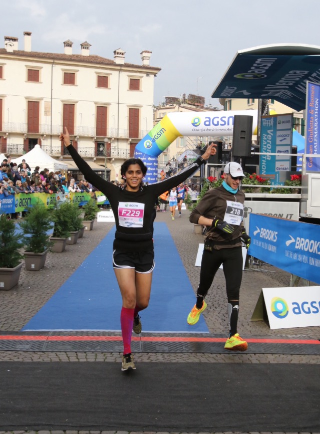 indian woman running through finish line